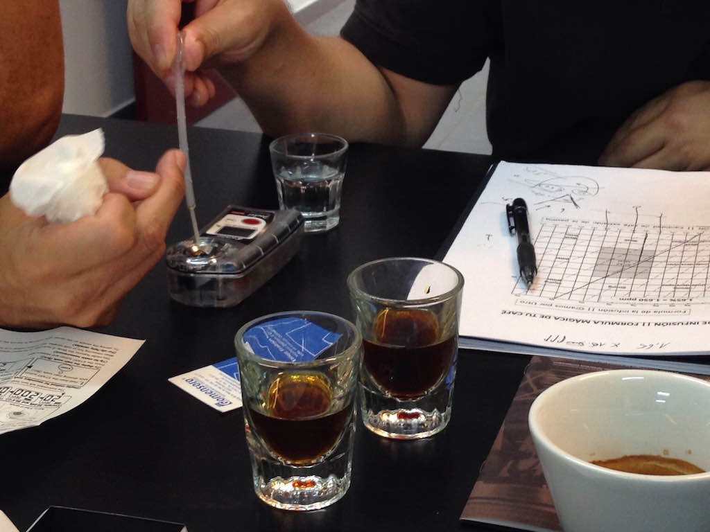 Buenos baristas midiendo el TDS y calculando la extracción del café en una mesa de trabajo