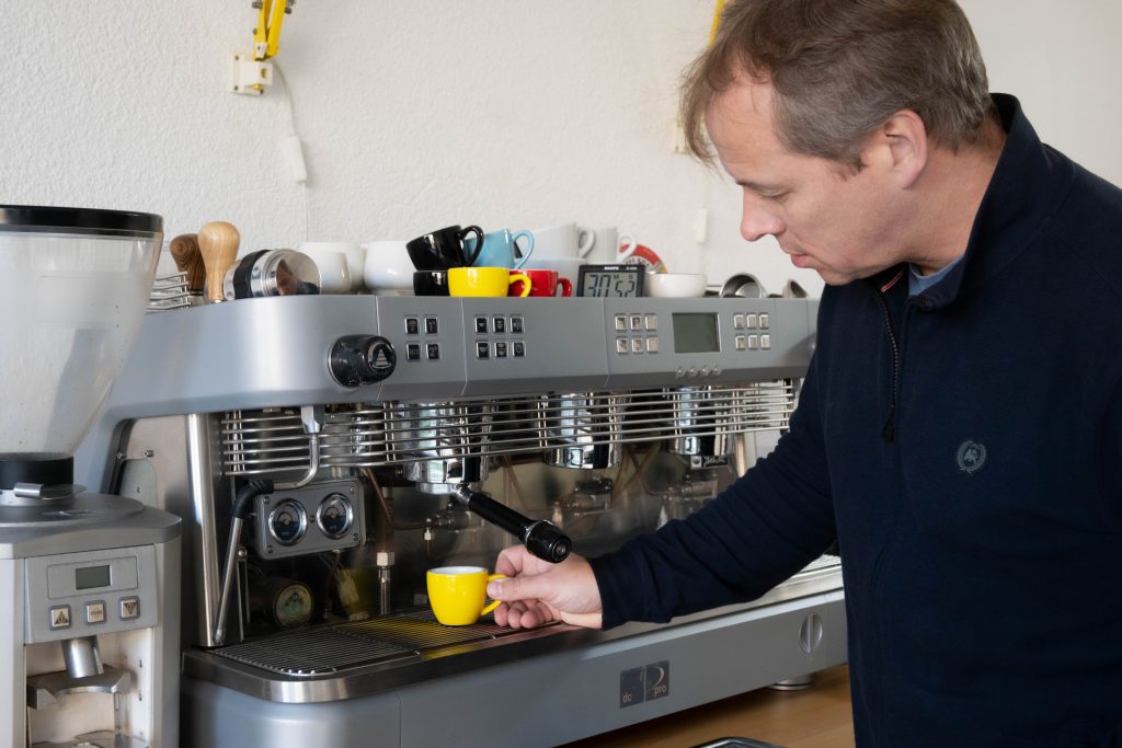 Barista emprendedor preparando un espresso en cafetería de especialidad